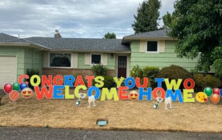 24 inch multi-color corex letters that spell out Welcome Home on a lawn in NE Portland, OR